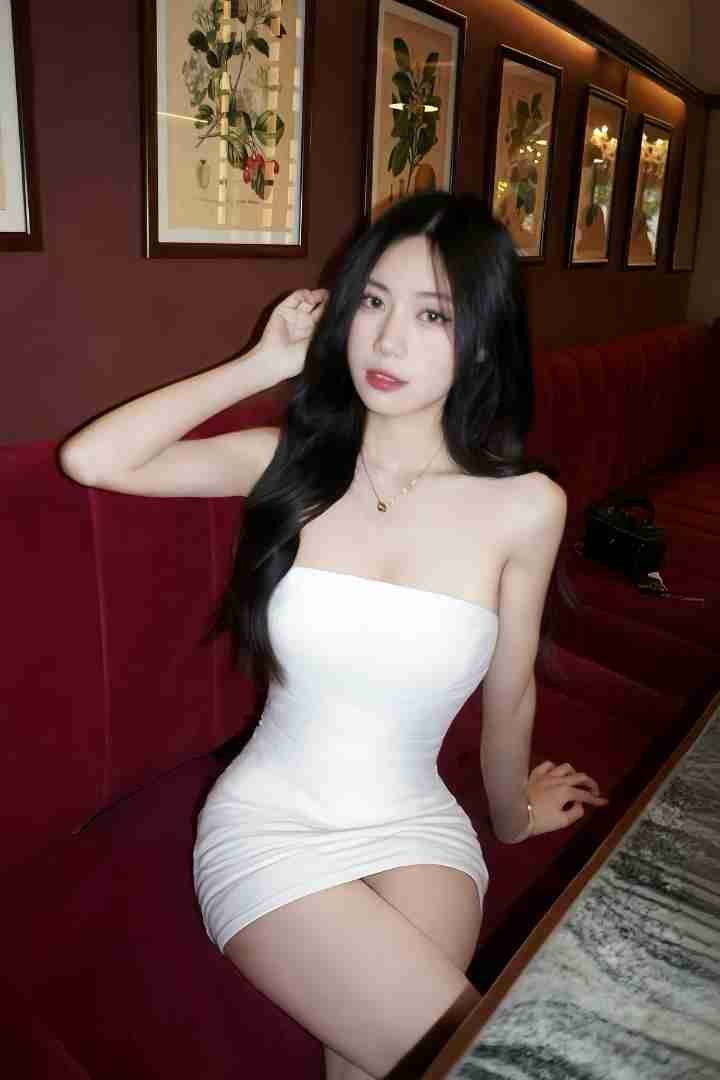 Malaysia Escort Girl Woman in white dress sitting on red couch in Blog Home setting Sex Service Kuala Lumpur