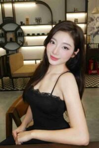 Malaysia Escort Girl Woman in black dress sitting indoors. Sex Service Kuala Lumpur