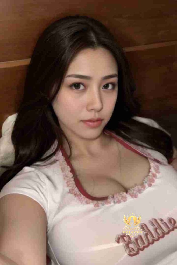 Attractive Asian woman with dark hair wearing a white top with "Baddie" text.
