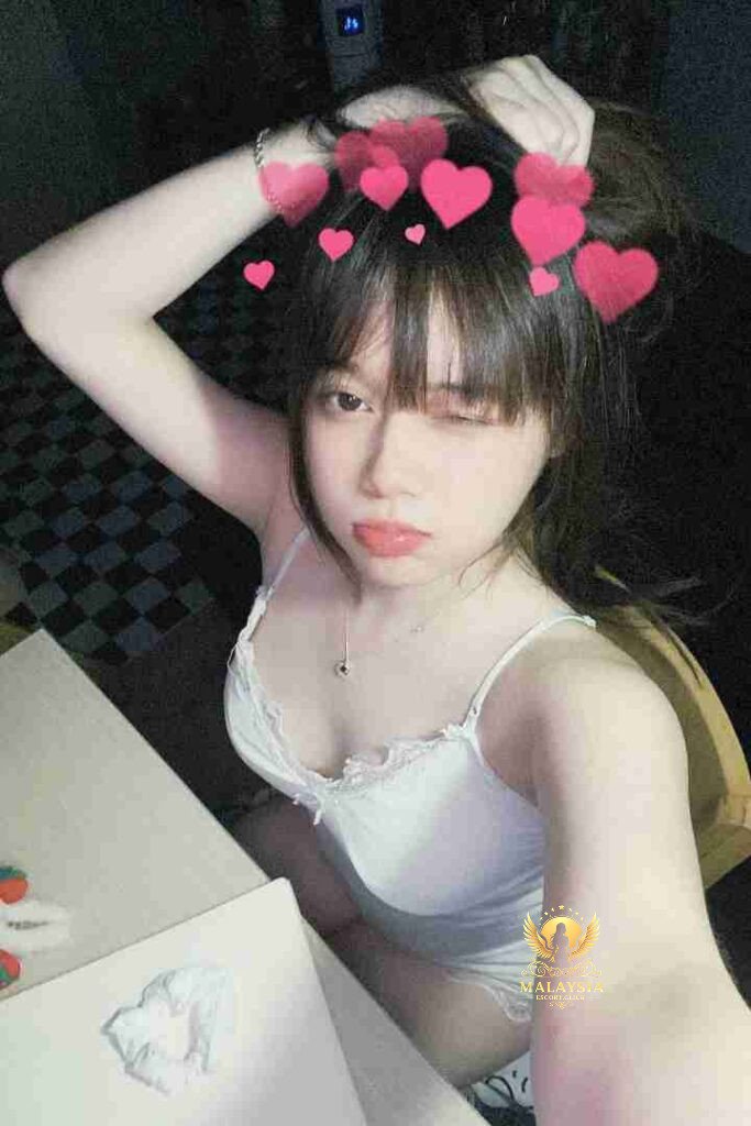 Cute Asian woman with bangs and hearts filter, wearing white camisole top and holding hair up.