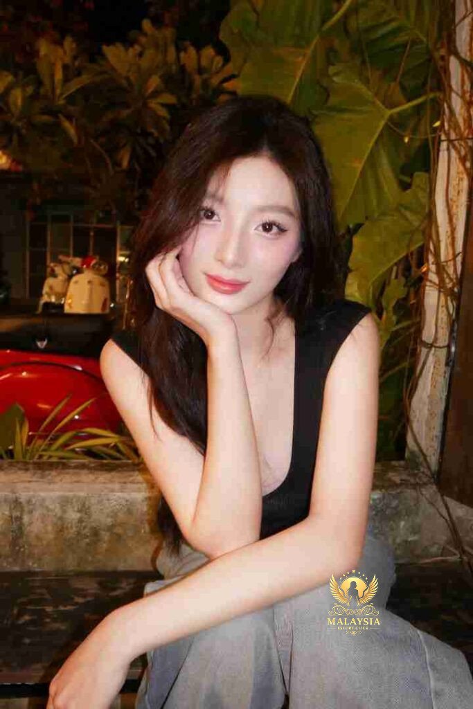 Attractive Asian woman with long hair sitting outdoors. Sassy Vietnamese escort vibe.