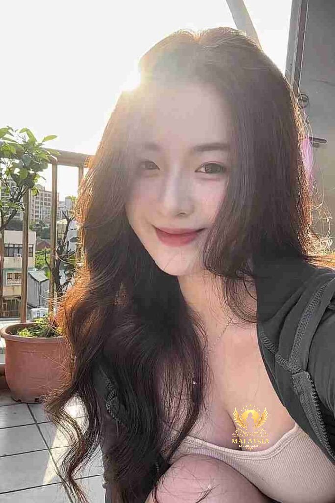 Smiling Asian woman with long wavy hair. Bubbly and cute. KL call girl.