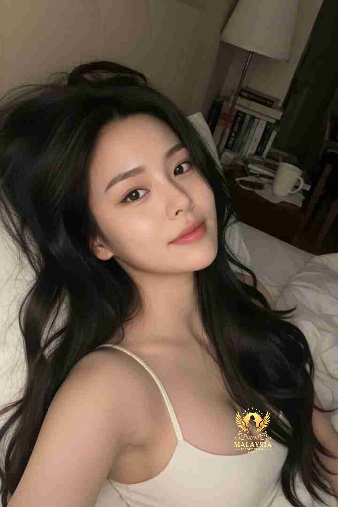 Beautiful Asian woman with long dark hair lying down in white top. Soft lighting, serene expression.