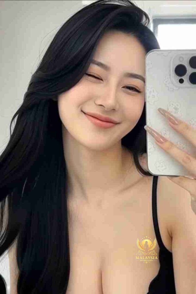 Smiling Asian woman with long black hair taking selfie with phone. Winking, pretty.