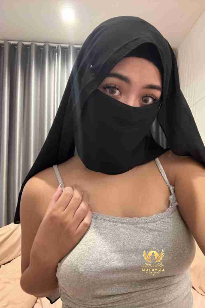 Malaysia Escort Girl Portrait of a woman with dark hair wearing a white top that says "Baddie. Sex Service Kuala Lumpur