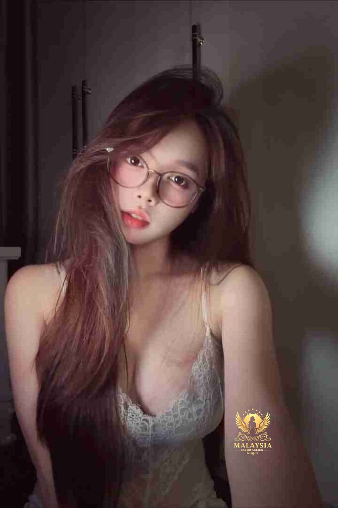 Woman with glasses and long hair, wearing a lace top. Soft lighting, portrait.